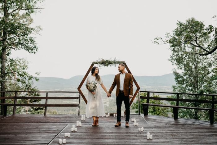 couple standing on the aisle with candles